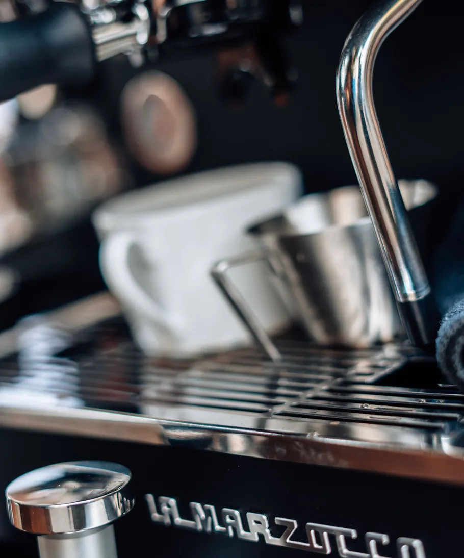 Espressomaschine mit Tasse und Dampfdüse.
