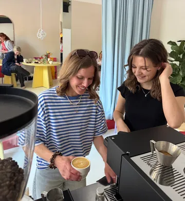 Zwei Frauen machen Kaffee in einem Café.