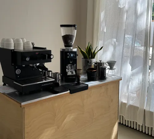 Kaffee-Station mit Espressomaschine und Mühle.