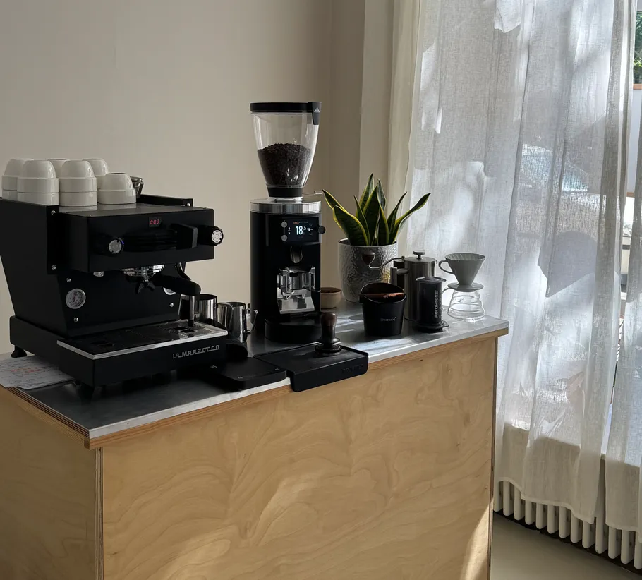 Coffee station with espresso machine and grinder.