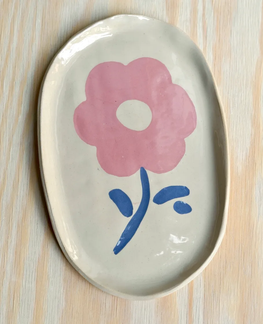 Ovaler Teller mit rosa Blumendesign.