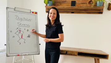 Frau präsentiert am Whiteboard im Büro.