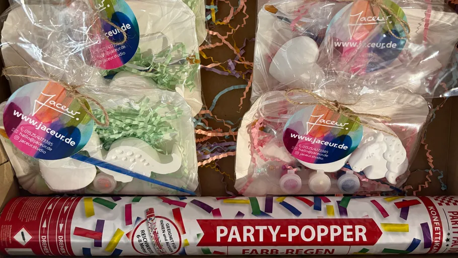 Partyartikel mit buntem Konfetti und Malkits.