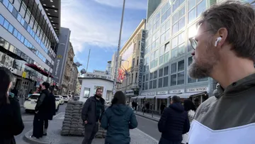 Personen gehen in der Nähe von Checkpoint Charlie, Berlin.