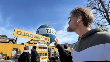 Man pointing at Trabiworld attraction, Berlin street.