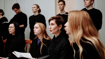 Gruppe von Menschen singt gemeinsam drinnen.