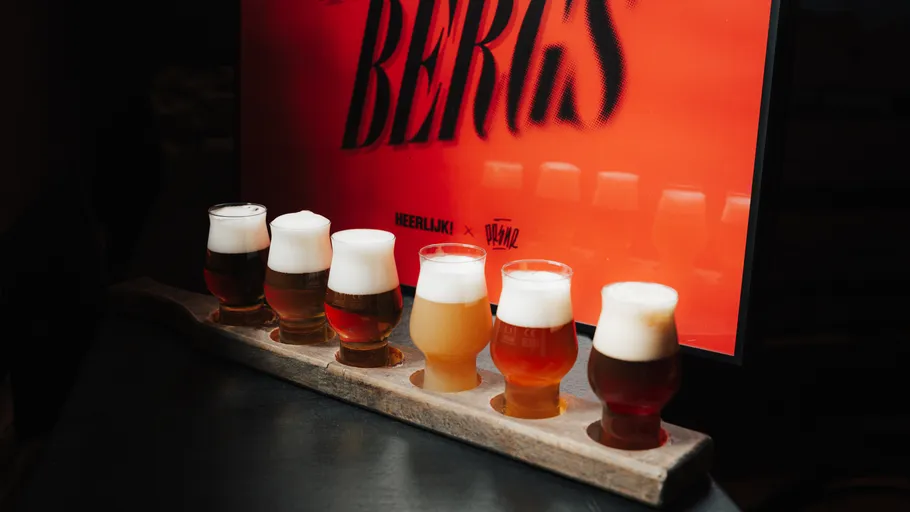 Fünf Biergläser auf einem Holztablett.