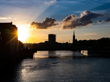 Sunset over the river surrounded by city buildings.