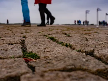 Steinweg mit Menschen, die in der Ferne gehen.