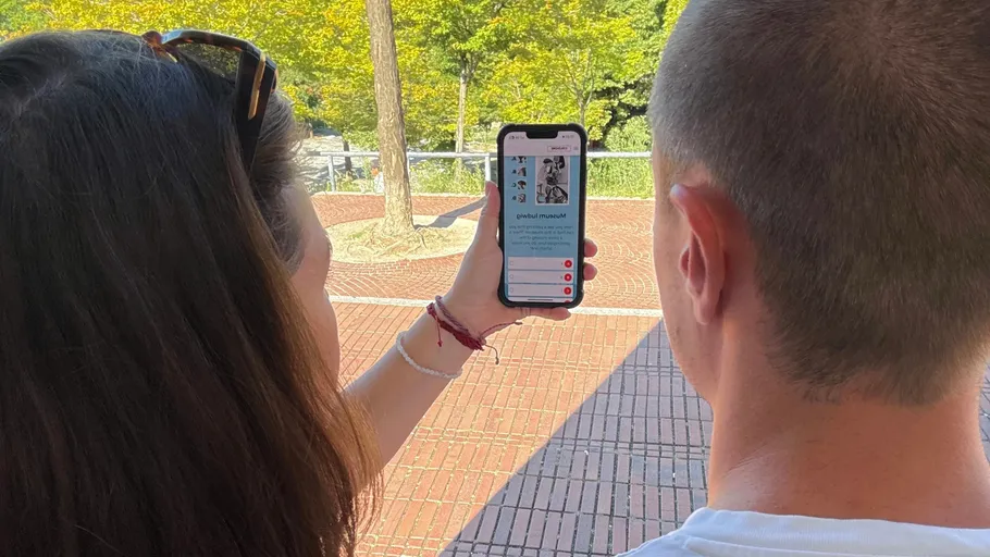 Zwei Personen betrachten Handy im Freien, schöne Umgebung.