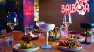 Cocktails and dishes on a restaurant table.