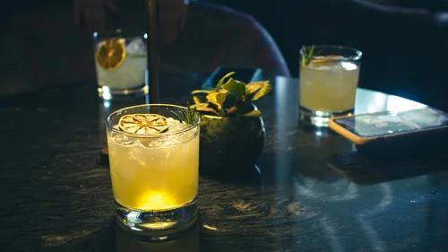 Zwei Cocktails auf einem schwach beleuchteten Tisch.