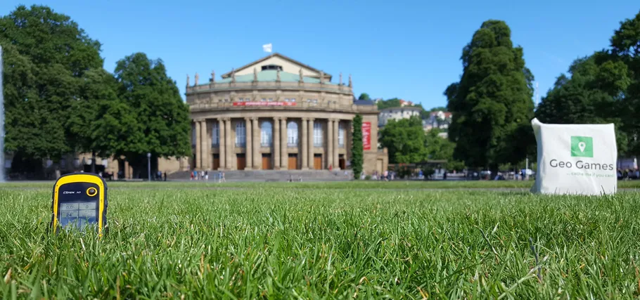 GPS-Gerät auf Gras, Gebäude im Hintergrund.