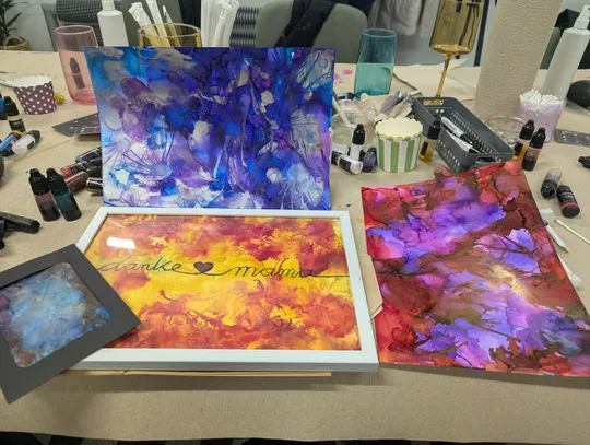 Colorful abstract paintings with art supplies visible.