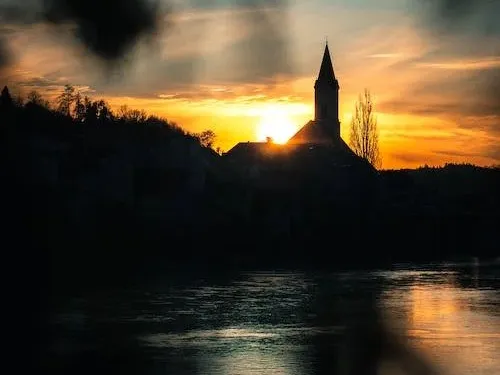 Silhouette of a church at sunset on the river.