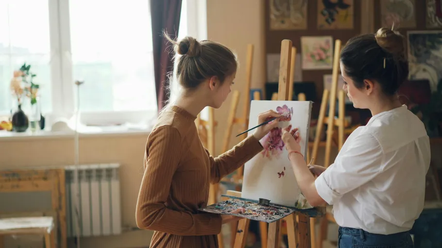 Two women painting in art studio.