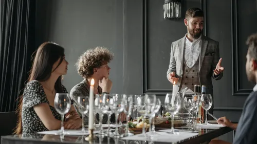 Person spricht am elegant gedeckten Tisch.