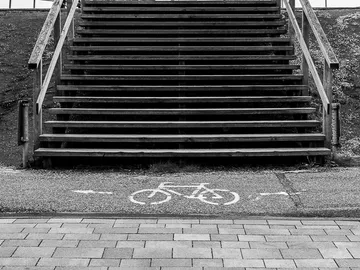 Wooden staircase leads to the top, surrounded by bike path.