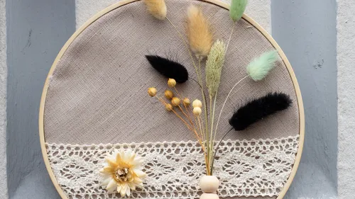 Dekorativer Stickrahmen mit Trockenblumen.