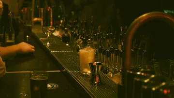 Bartheke mit Getränken und Cocktailwerkzeugen.