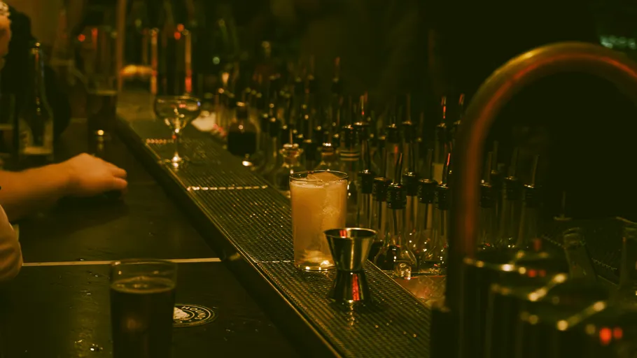 Bartheke mit Getränken und Cocktailwerkzeugen.