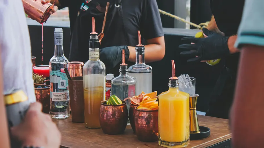 Bartender preparing drinks at outdoor bar.