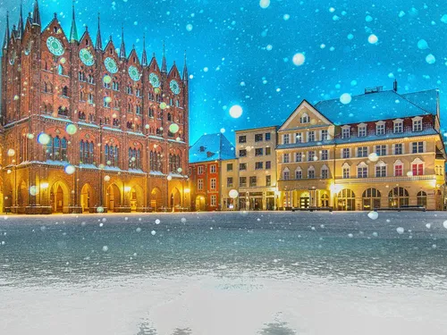 Snow-covered landscape with historic buildings and blue skies.