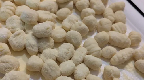 Homemade gnocchi on a floured surface.