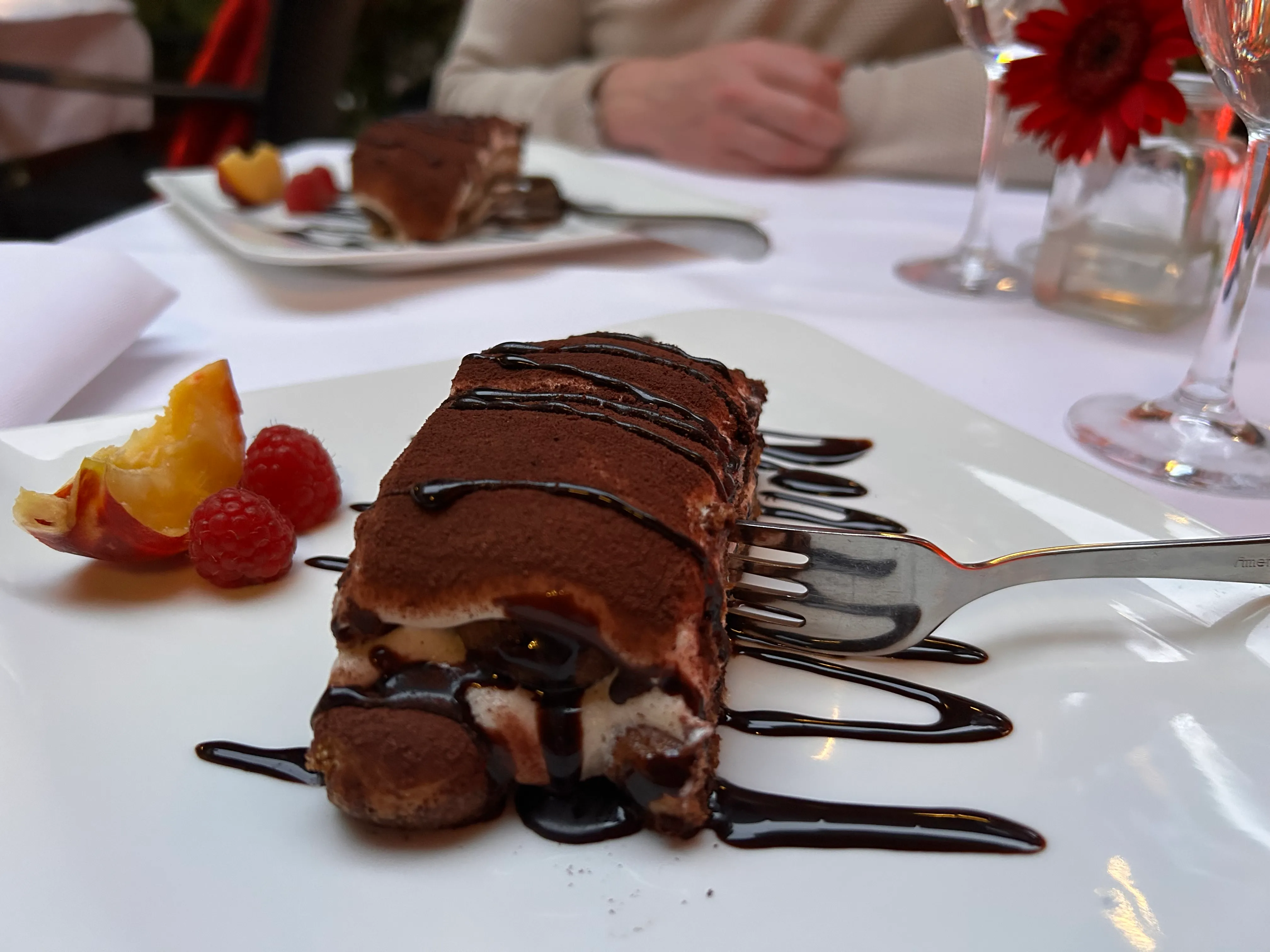 Tiramisu-Schnitte mit Schokoladensoße, Esstisch.