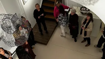 People gathered at art gallery viewing installation.