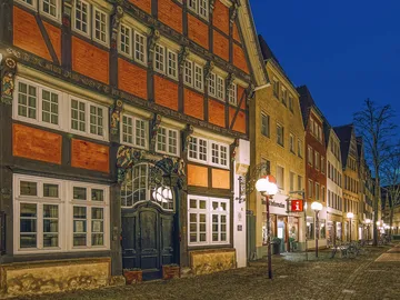 Fachwerkhaus beleuchtet, Abendstimmung in einer Straßenansicht.