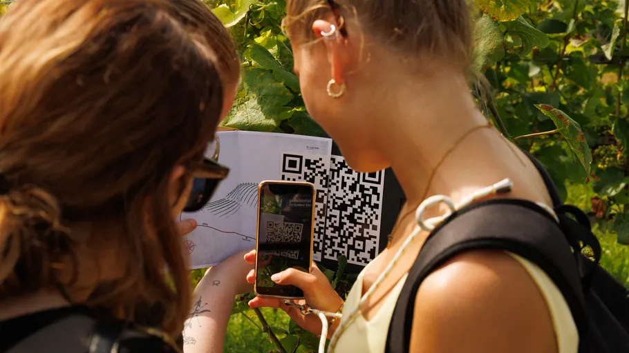 People scanning QR code with smartphone outdoors.
