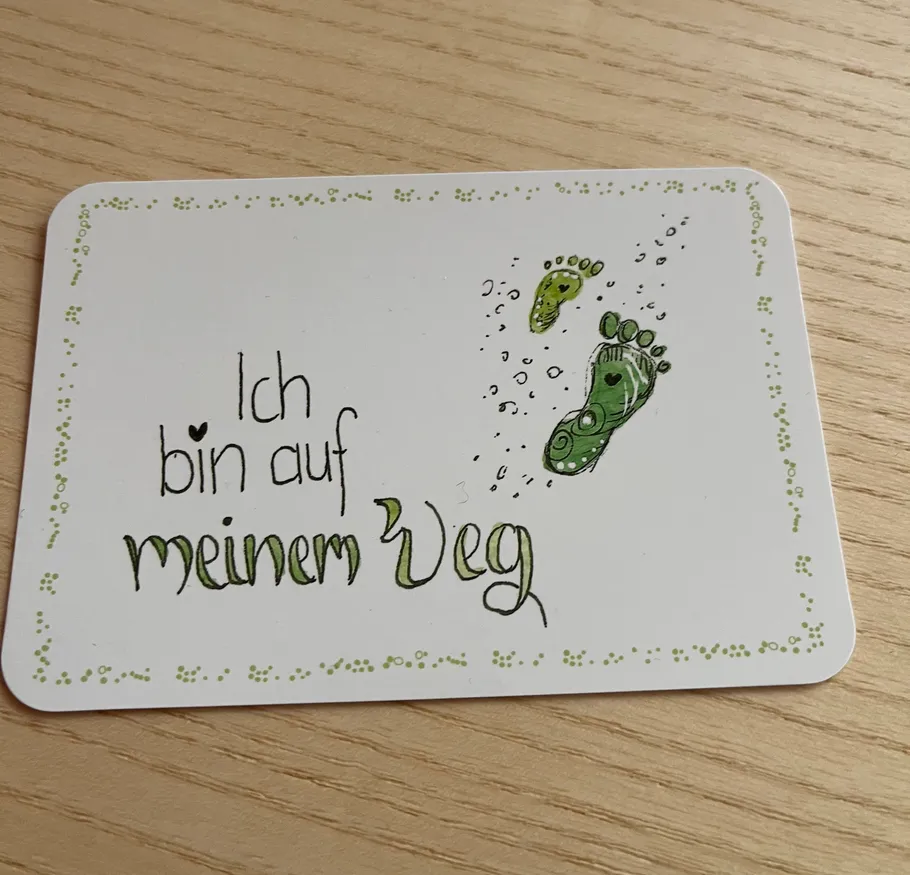 Handgeschriebene Karte mit Fußabdrücken auf Tisch.