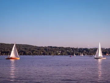 Zwei Segelboote fahren ruhig auf einem See.