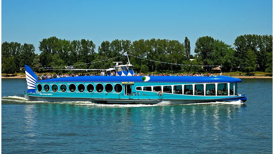Blue riverboat cruising on a sunny river.
