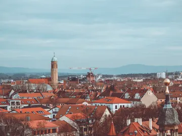 Dächer einer Stadt, Türme ragen heraus, Bauarbeiten im Hintergrund.