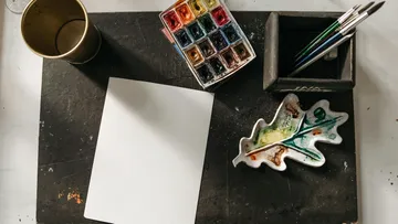 Art supplies on a dark table surface.