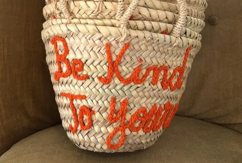 Woven basket with embroidered text on chair.