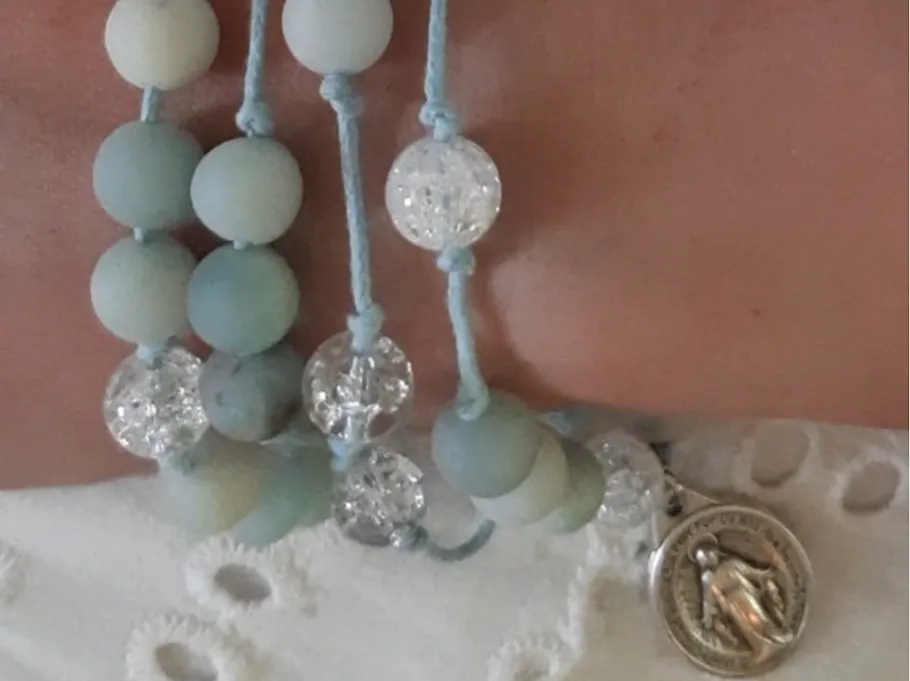 Beaded bracelet with medallion on wrist.