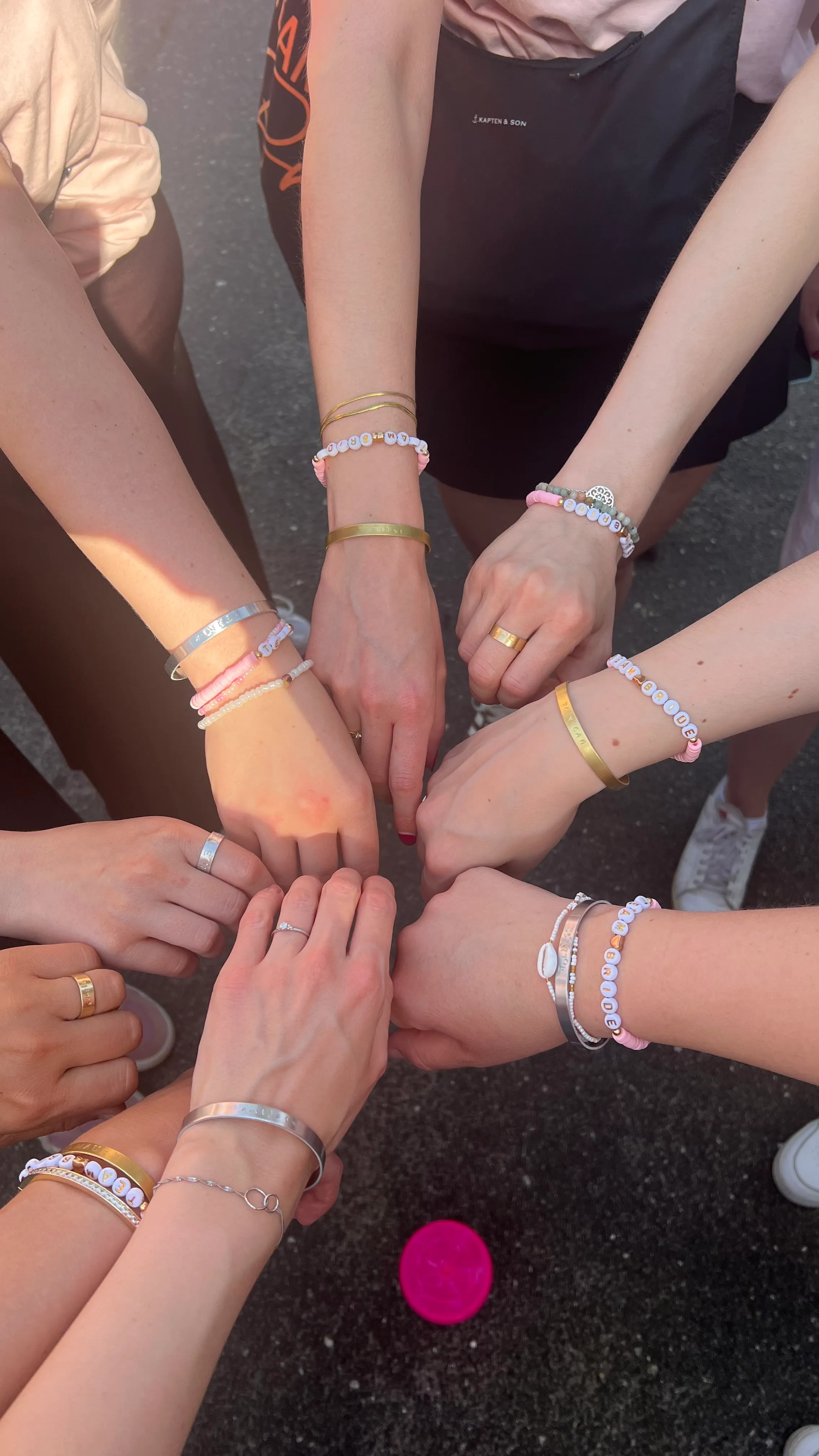 Gruppe von Händen mit Armbändern im Freien.