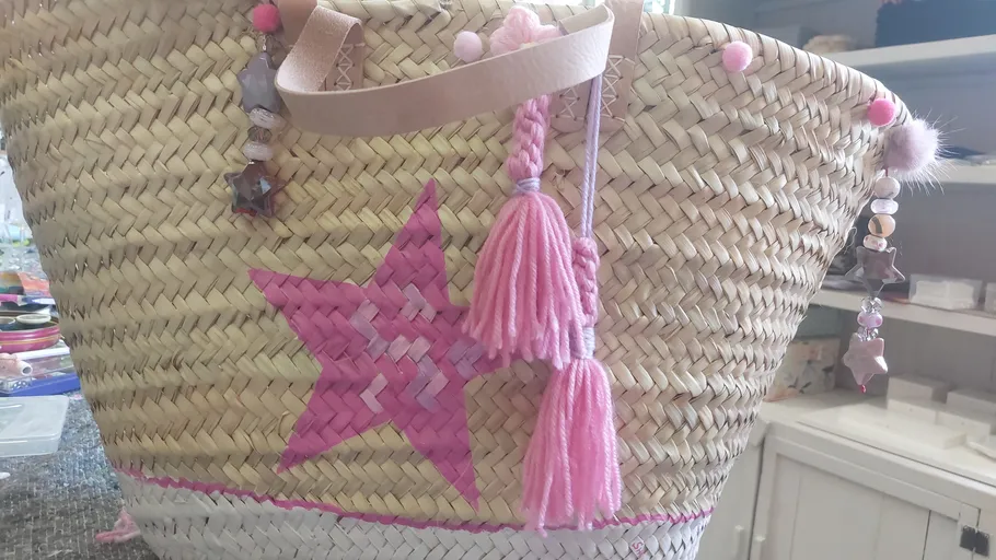 Geflochtener Korb mit rosa Stern und Quasten.