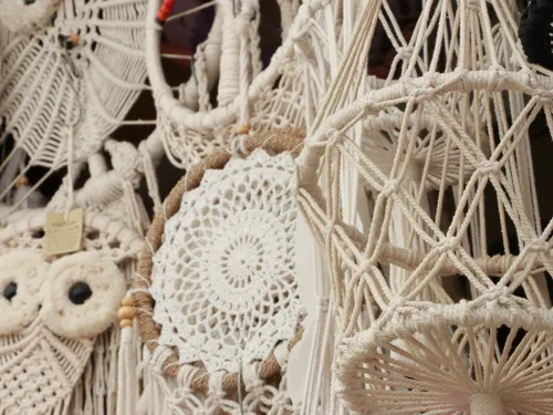 Handgefertigte Makramee-Dekorationen hängen in einem Markt.