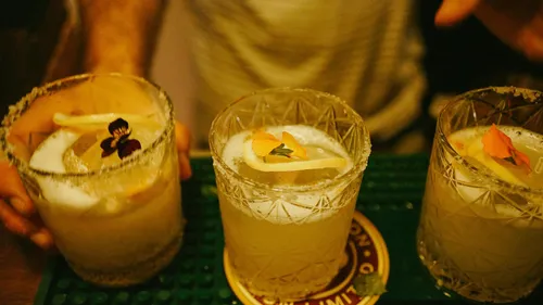 Three decorative cocktails on a bar counter.