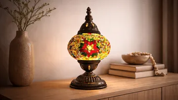 Mosaic lamp glowing on wooden table.