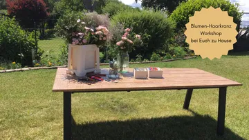 Table with flower arrangement tools in garden.