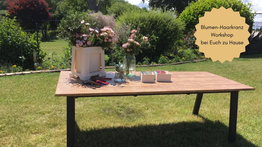 Tisch mit Blumenarrangement-Werkzeugen im Garten.