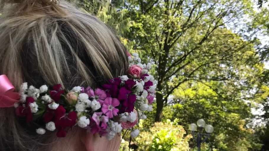 Woman with flower crown in park setting.