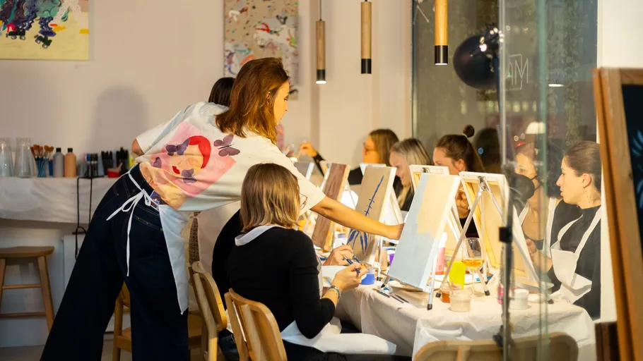 Personen malen in einem Kunstkurs drinnen.