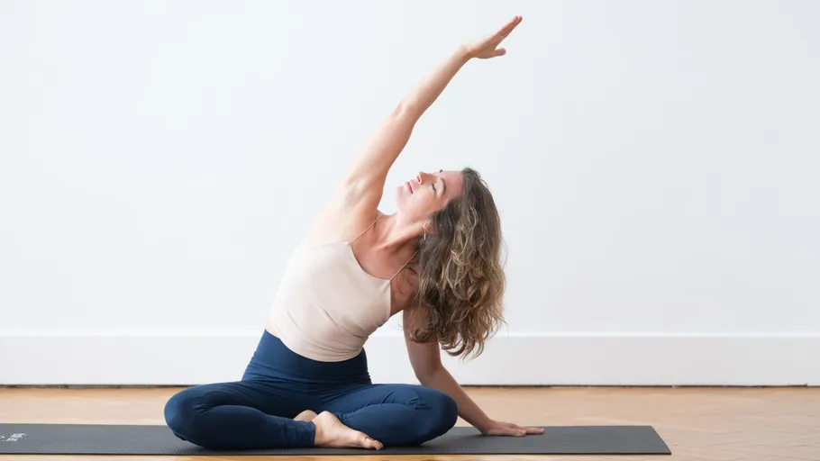Woman performing yoga pose on mat indoors.