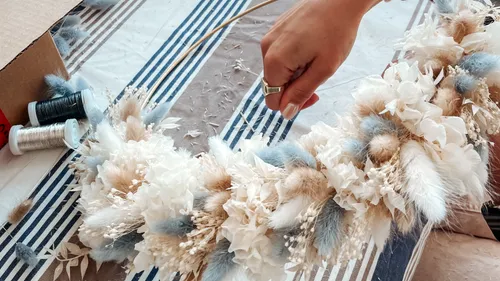 Hand crafting a dried flower wreath.